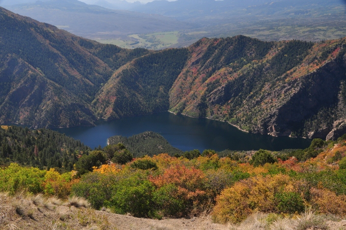 a beautiful deep blue lake surrounded by autumn trees